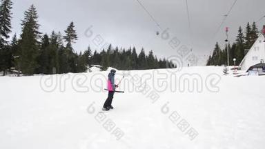 滑雪者在山上使用滑雪升降机锚。 人们在雪覆盖的景观上缓慢地上坡移动。 冬季运动